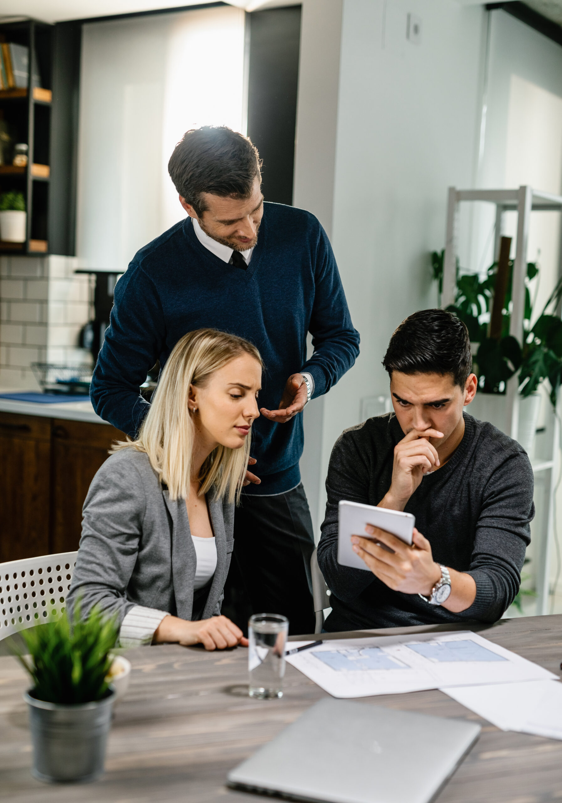 Young couple using touchpad while having a meeting with real estate agent at home.